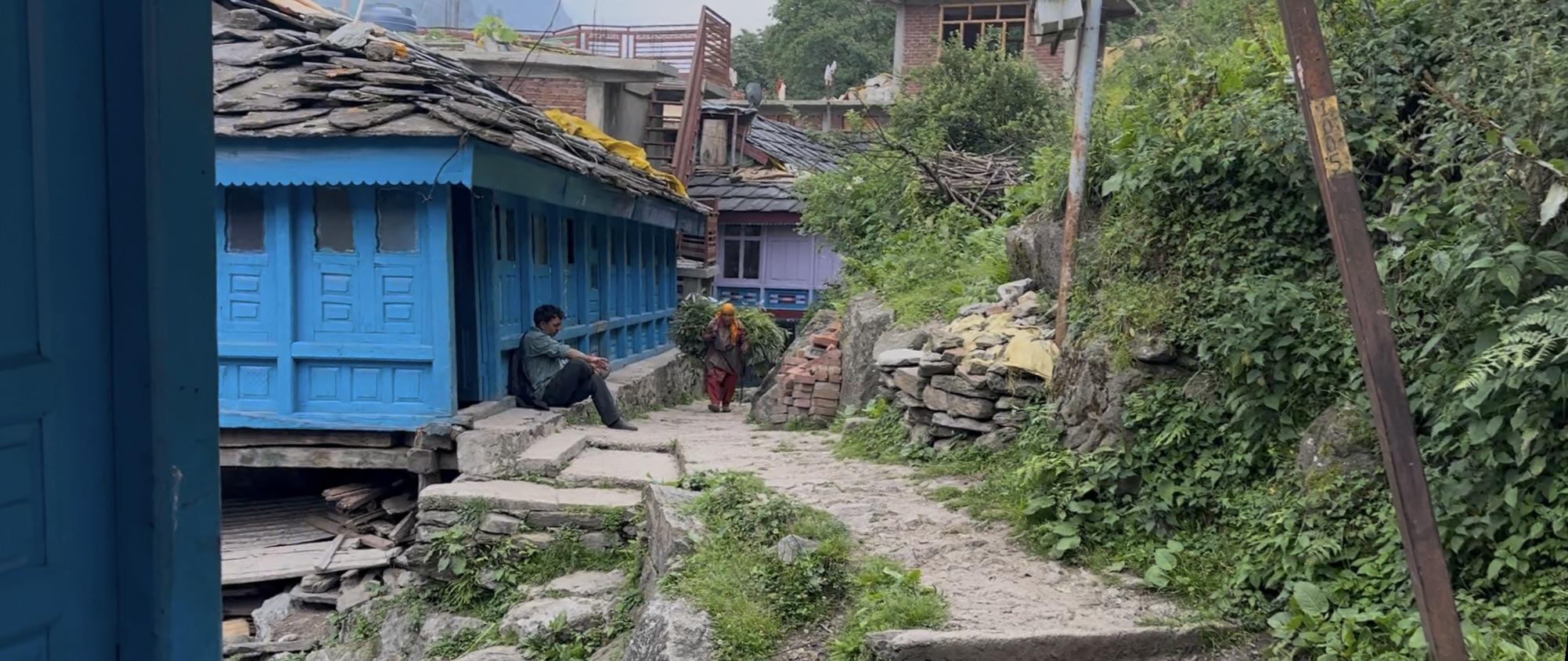 A stone path through the village with traditional blue houses