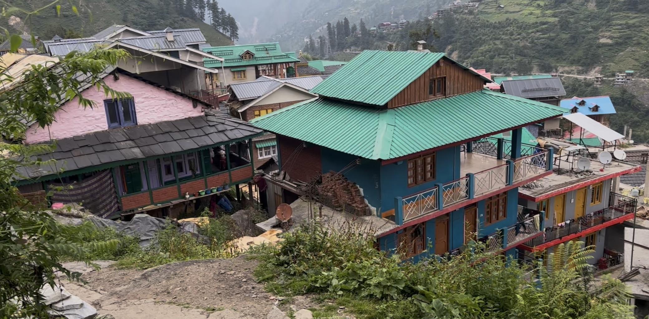 Colourful hillside houses with green and blue rooftops in Shilha